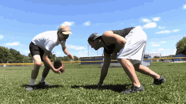 two men are playing a game of football on a field with a sign in the background that says ' a ' on it