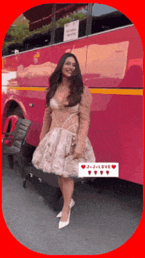 a woman in a white dress stands in front of a pink bus with the words j + j + love on the bottom