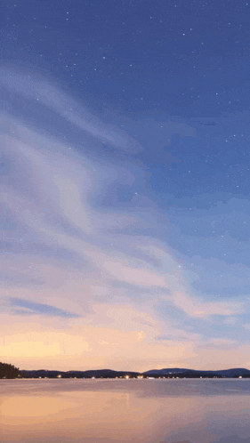 a sunset over a lake with a starry sky