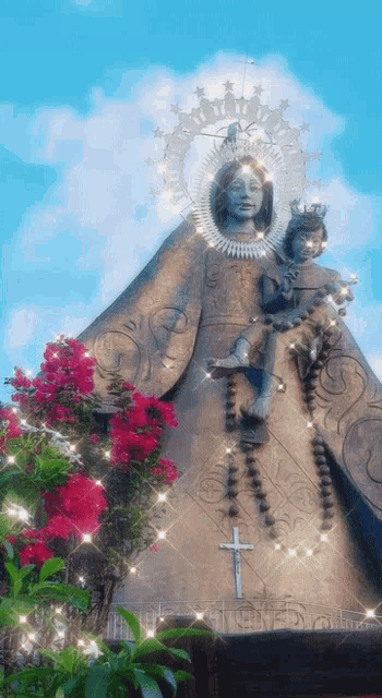 a statue of a woman holding a child with a cross on the side