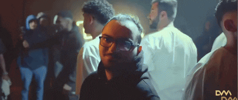 a man wearing glasses stands in a crowd with a dw logo on the bottom left