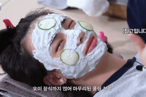 a woman has a mask on her face with cucumber slices on it
