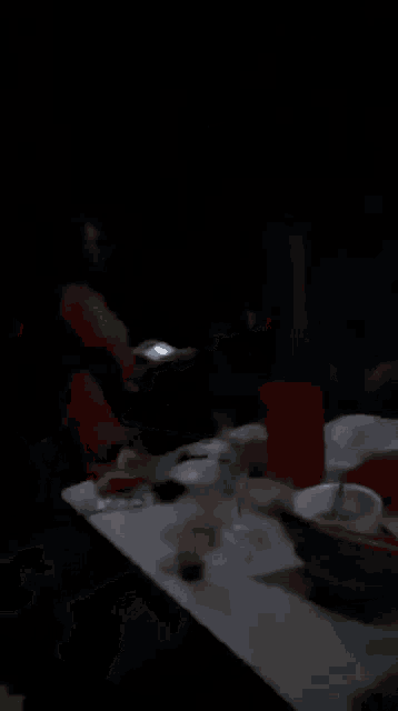 a group of people are sitting at a table in the dark .