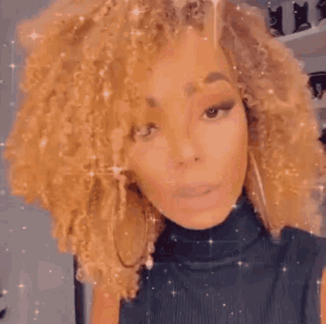 a woman with curly blonde hair and hoop earrings is taking a selfie in front of a shelf .