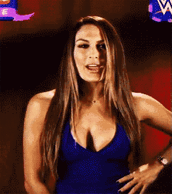 a woman in a blue dress with a plunging neckline is standing in front of a w logo