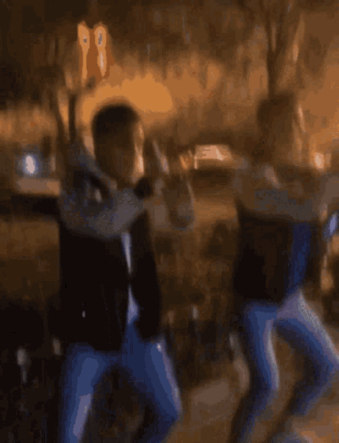 a blurry picture of two people dancing with trees in the background