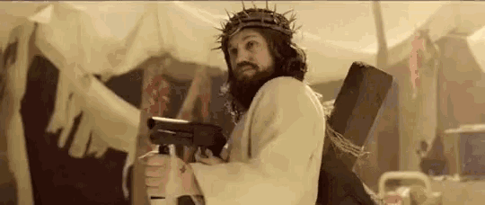 jesus is wearing a crown of thorns and holding a gun while carrying the cross .