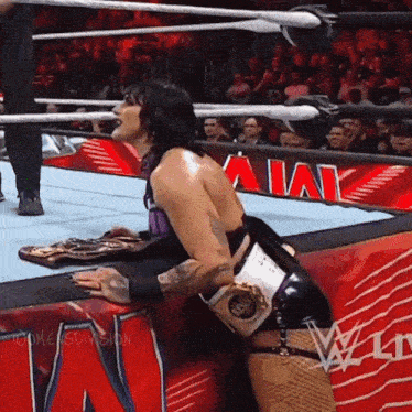 a woman in a wrestling ring with a sign that says ' aik ' on it