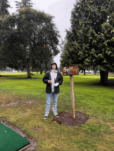 a man stands next to a sign that says 5