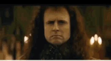 a man with long hair is making a funny face .