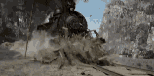 a train is going down the tracks in the middle of a mountain range .