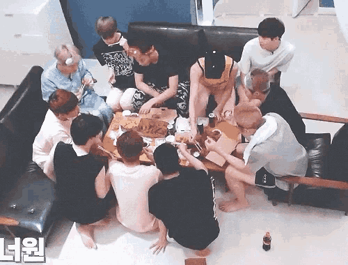 a group of people are sitting around a table with a coca cola bottle in front of them