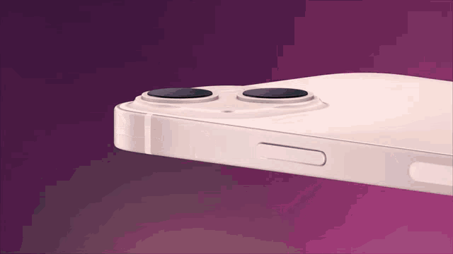 a close up of a white iphone with two cameras on a purple background .