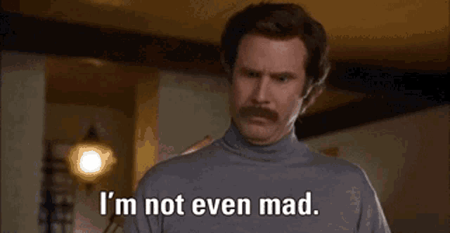 a man with a mustache is standing in a room and saying `` that 's amazing . ''