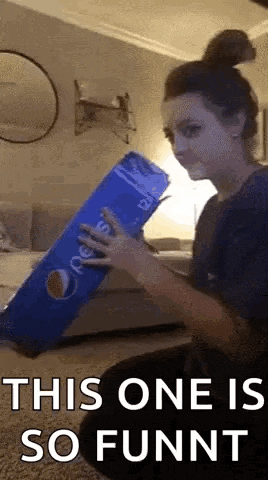 a woman is holding a giant pepsi can in her hand .