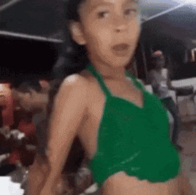 a young girl is wearing a green crop top and a green apron .