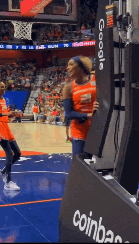 a basketball game is being played in front of a crowd and a sign that says google
