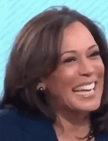 a close up of a woman 's face smiling and wearing earrings