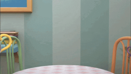 a cartoon teapot is pouring a cup of tea onto a table