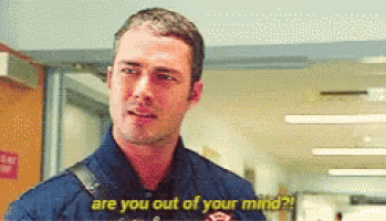 a man in a fireman 's uniform is talking to another man in a hospital .