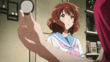 a girl in a school uniform is looking at herself in the mirror