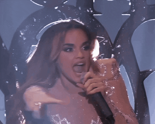 a woman singing into a microphone with her tongue sticking out