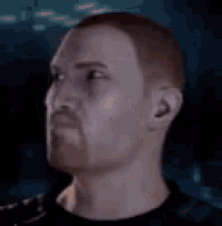 a man with a beard and mustache is looking up at the camera .