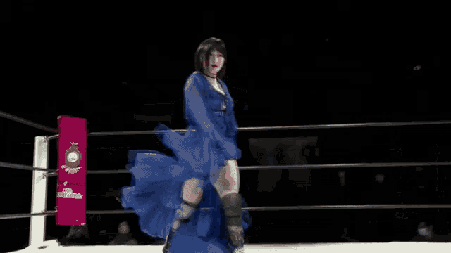 a woman is kneeling down in a wrestling ring .