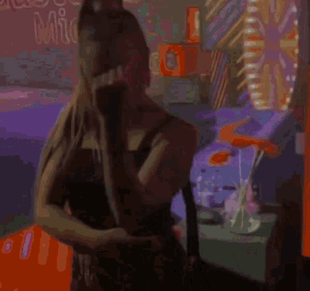 a woman talking on a cell phone in front of a sign that says ' good music '