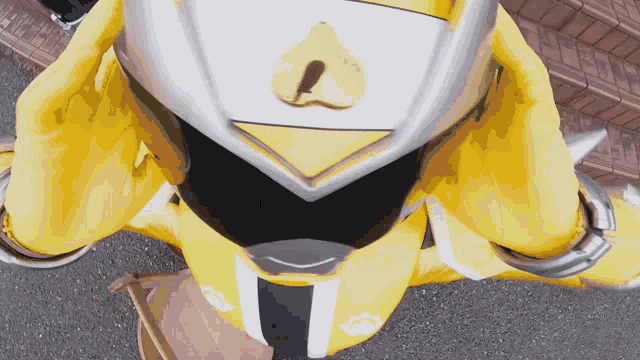 a person in a yellow superhero costume has a yellow l on their face