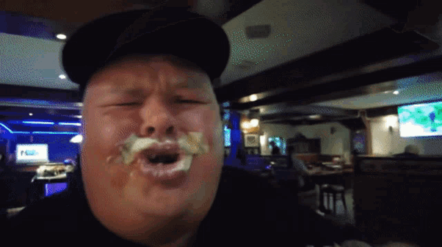 a man wearing a black hat is making a funny face with his mouth open