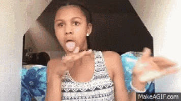 a young girl is sitting on a couch with her tongue out and making a funny face .