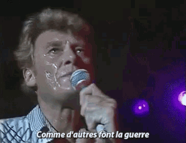 a man is singing into a microphone with the words comme d' autres font la guerre written below him