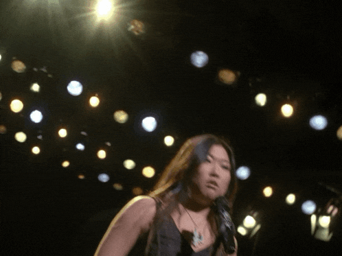 a woman is singing into a microphone on stage