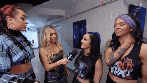 a group of women are standing in a hallway and one of them is wearing a shirt that says rudo