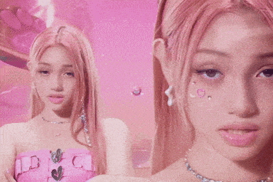 a girl with pink hair is wearing a pink top and a necklace .