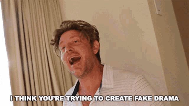 a man is laughing with the words i think you 're trying to create fake drama below him