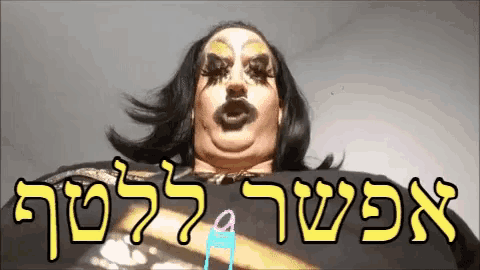 a drag queen is making a funny face with hebrew writing behind her