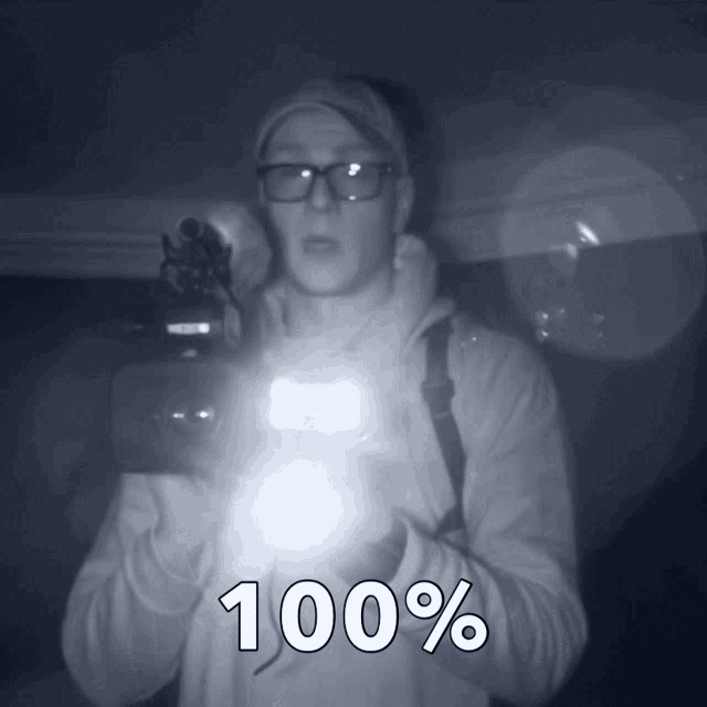 a man with glasses is holding a flashlight and the text 100 % is above him