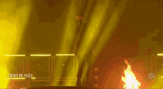 twenty one pilots performing on stage with a fire