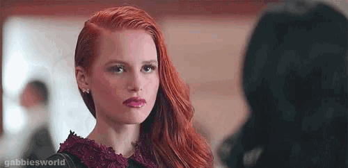 a woman with red hair is standing next to a woman with black hair .