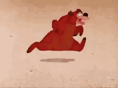 a cartoon bear is standing on its hind legs on a sandy surface .
