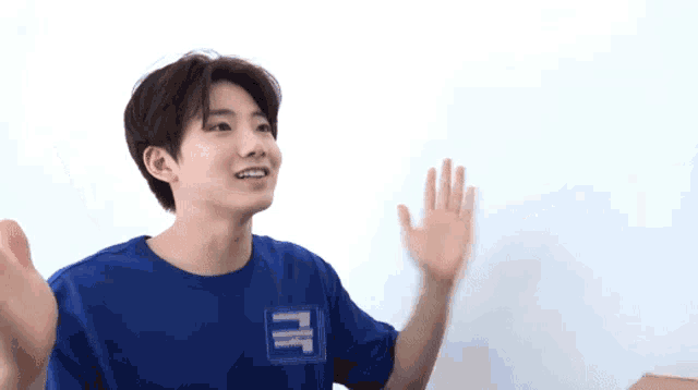 a boy wearing a blue shirt with the letter k on the front
