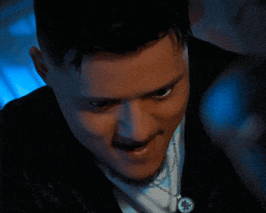 a close up of a man 's face with a necklace on his neck