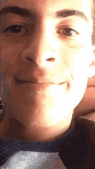 a close up of a man 's face with a sweater on