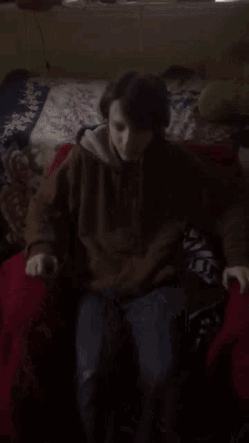 a person covering their face with their hands in a dark room