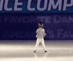 a young boy is standing on a ice rink in front of a banner that says ice comp