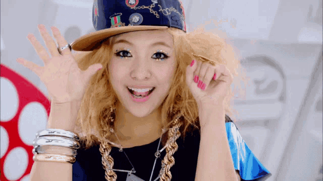 a woman wearing a hat with the letter t on it is smiling