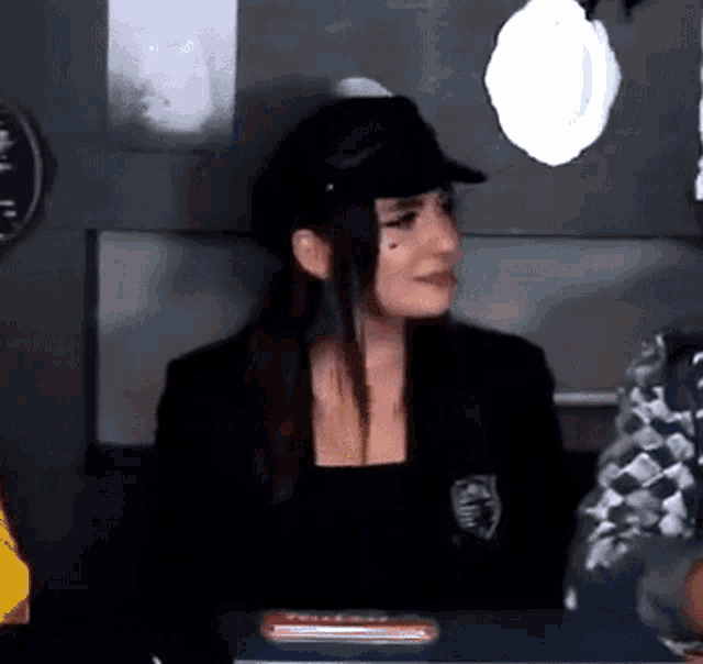 a woman wearing a hat is sitting at a table with a man .