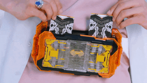 a person is holding a toy that has a yellow and black item on it